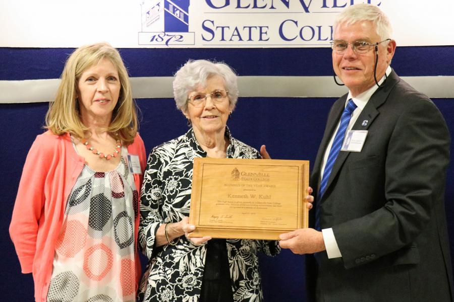 Faye (Kuhl) Chambers and Wilda Kuhl accept the Alumnus of the Year award on behalf of Kenneth Kuhl from Dennis Carpenter (right)