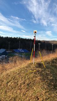 A surveying tripod set up on a hill