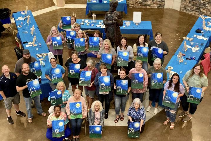 WLC Members Show off paintings of a lightning bug in a jar