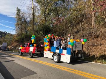 Club members riding a float with balloons