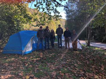 Forestry Club members posing in front of pitched tents