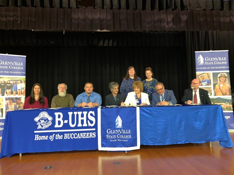 Representatives from Upshur County Schools and Glenville State College sign a Memorandum of Understanding for the innovative Home Grown Teacher and Dual Enrollment Programs on March 28 in the B-UHS Auditorium; (seated, l-r) Katie Yeager, Dr. Greenbrier Almond, Eddie Vincent, Dr. Debra Harrison, Dr. Sara Stankus, Dr. Victor Vega, and Dr. Jeff Hunter; (standing, l-r) Rachel Adams and Rachel Clutter