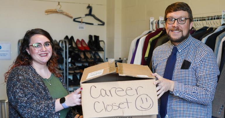 Calhoun Banks Marketing Director Ammanda Frame (left) presents some of the items collected by Calhoun Banks employees to Glenville State University Marketing Director Dustin Crutchfield for the campus Career Closet.