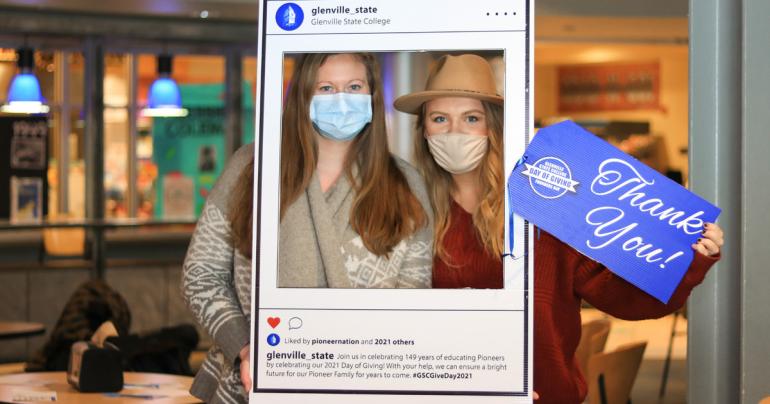 Glenville State College employees Tegan McEntire (left) and Cheyenne Singleton at the Day of Giving “thank you” selfie station on February 19.