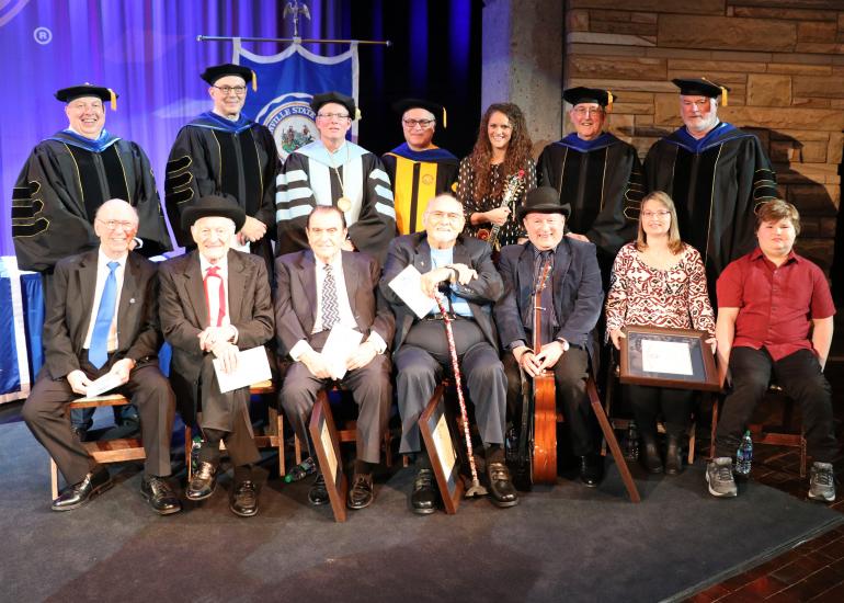 (seated, l-r) Buddy Griffin, Jesse McReynolds, Bobby Osborne, Sonny Osborne, Ronnie Reno accepting on behalf of Mac Wiseman, Jeanine McReynolds Reynolds and James Reynolds accepting on behalf of Jim McReynolds (standing, l-r) GSC Board of Governors Vice Chair Tim Butcher, GSC Board of Governors Member Mike Rust, GSC President Dr. Tracy Pellett, GSC Provost Dr. Victor Vega, GSC Bluegrass Music Program Director Dr. Megan Darby, GSC Board of Governors Member Dr. Bill Deel, GSC Board of Governors Chair Greg Smith (seated, l-r) Buddy Griffin, Jesse McReynolds, Bobby Osborne, Sonny Osborne, Ronnie Reno accepting on behalf of Mac Wiseman, Jeanine McReynolds Reynolds and James Reynolds accepting on behalf of Jim McReynolds (standing, l-r) GSC Board of Governors Vice Chair Tim Butcher, GSC Board of Governors Member Mike Rust, GSC President Dr. Tracy Pellett, GSC Provost Dr. Victor Vega, GSC Bluegrass Music Program Director Dr. Megan Darby, GSC Board of Governors Member Dr. Bill Deel, GSC Board of Governors Chair Greg Smi
