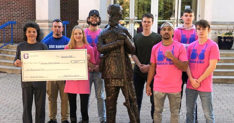 American Cancer Society representative Charla Barrett (left) holds a $1,000 check presented to the American Cancer Society from members of the Glenville State College Boxing Team. The money donated was raised as part of their “Knock Out Cancer” fundraiser.