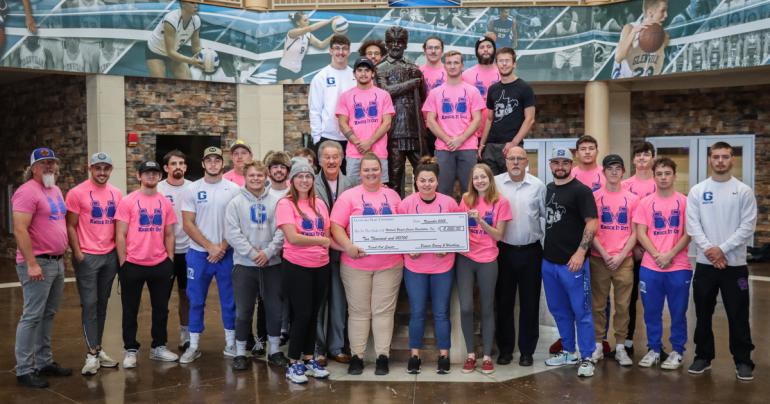 Glenville State University student athletes and members of the Athletic Training staff, Head Boxing Coach Duane Chapman, Head Wrestling Coach Dylan Cottrell, Athletic Director Jesse Skiles, and President Dr. Mark Manchin with a $2,000 check to be presented to the National Breast Cancer Foundation. (GSU Photo/Seth Stover)
