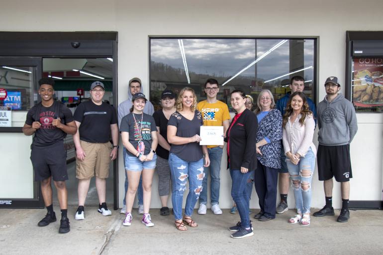 Students in Kandas Queen’s Principles of Retailing class present a certificate of appreciation to Glenville Foodland Assistant Manager Tiffany Bennington