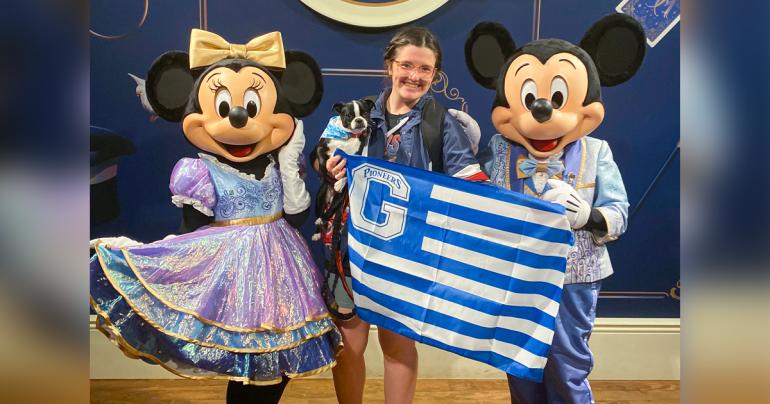Madelin Toy Disney College Program Flanked by Minnie and Mickey Mouse, Glenville State University student Madelin Toy and her dog Hank hold up a Glenville State flag. Toy will be in Florida participating in the Disney College Program through the beginning of 2023. (Courtesy Photo)