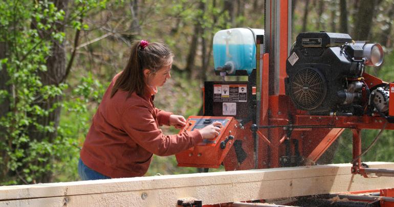 Glenville State University student Gabrielle Dean operates a portable sawmill.