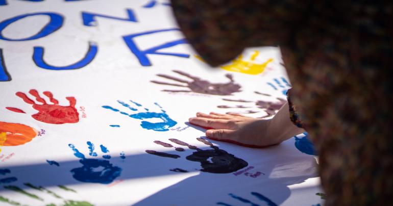 These Hands Don't Hurt Banner A student applies their handprint to the “These Hands Don’t Hurt” banner. The activity was part of Glenville State University’s Domestic Violence Awareness Month activities. (GSU Photo/Kristen Cosner)