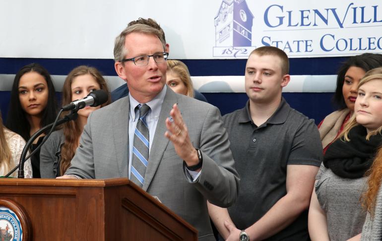 President Pellett, flanked by students, announces new initiatives to save students money at a Thursday press conference
