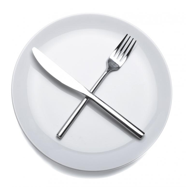 A Plate, Fork and Knife. A plate with a fork and knife crossed over top of it.