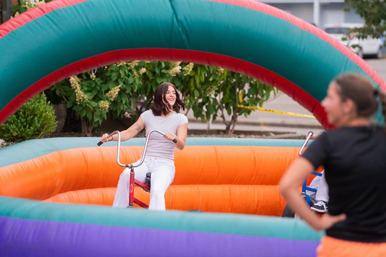 A student bikes inside an inflatable course