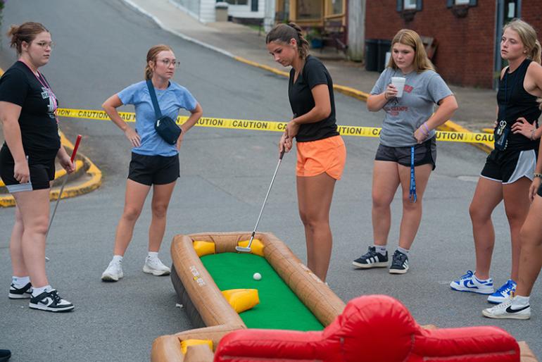 Students play mini-golf on an inflatable course