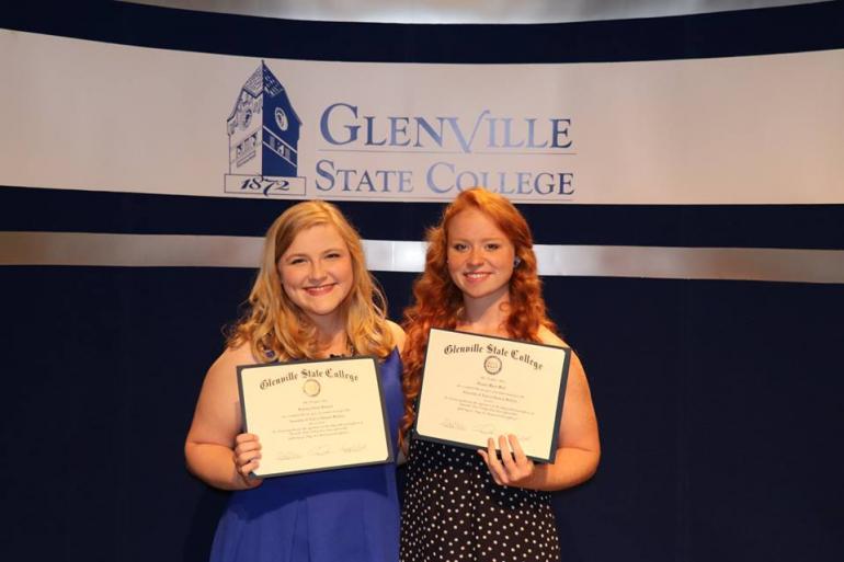 Two women holding awards.