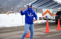 Glenville State College student Hunter Hickman motions for a driver to pull ahead as they approach the vaccine station during a COVID-19 vaccine clinic held at the Sue Morris Sports Complex in Glenville.