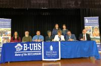 Representatives from Upshur County Schools and Glenville State College sign a Memorandum of Understanding for the innovative Home Grown Teacher and Dual Enrollment Programs on March 28 in the B-UHS Auditorium; (seated, l-r) Katie Yeager, Dr. Greenbrier Almond, Eddie Vincent, Dr. Debra Harrison, Dr. Sara Stankus, Dr. Victor Vega, and Dr. Jeff Hunter; (standing, l-r) Rachel Adams and Rachel Clutter