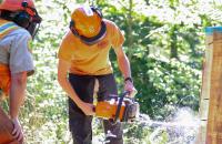 West Virginia Division of Forestry employee Johnny King (left) watches as Glenville State College student Adem Hupp practices boring into a tree during the Timber Felling and Chainsaw Safety Workshop. (GSC Photo/Dustin Crutchfield)
