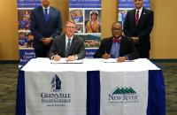 (seated) Glenville State College President Dr. Tracy Pellet and New River Community and Technical College President Dr. L. Marshall Washington sign agreement documents between the two institutions; (standing) GSC's Vice President for Academic Affairs Dr. Gary Morris and New River CTC Vice President for Academic Affairs Dr. Richard B. Pagan