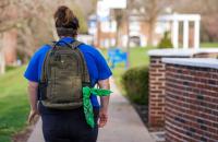 A student walking on the Glenville State University campus with a green bandana tied to their backpack. As part of the ongoing Green Bandana Initiative, Glenville State students are completing mental health training this spring. Once the training is complete, students will receive a green bandana that, when displayed on their backpacks or elsewhere, signals to other students that they are open to talking and are a source of support.