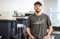 Glenville State University student Jared Bishop stands near his experiment setup inside the Department of Land Resources Environmental Science lab. (GSU Photo/Kristen Cosner)