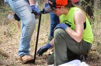 Glenville State University Natural Resource Management student Della Moreland places a sapling in the ground as another student uses a tree-planting bar to create an opening in the soil. (GSU Photo/Seth Stover)