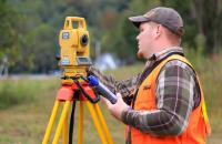A former Glenville State University student uses land surveying equipment in the field. Graduates of the land surveying program are invited back to Glenville State for a reunion celebrating 50 years of the program. (GSU Photo/Kristen Cosner)