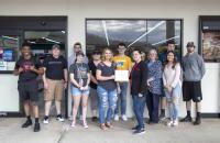 Students in Kandas Queen’s Principles of Retailing class present a certificate of appreciation to Glenville Foodland Assistant Manager Tiffany Bennington