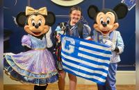 Flanked by Minnie and Mickey Mouse, Glenville State University student Madelin Toy and her dog Hank hold up a Glenville State flag. Toy will be in Florida participating in the Disney College Program through the beginning of 2023. (Courtesy Photo)