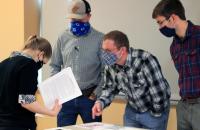 Glenville State College Honors Program students (standing, l-r) Asa Dick, Eli Henthorn, and Jacob Amick explain their Pioneer Showcase entry to an attendee. Their work, a surveying and preservation project on the “Lost Graves of Gilmer County,” tied for first place in the Honors Program Presentations category. (GSC Photo/Dustin Crutchfield)