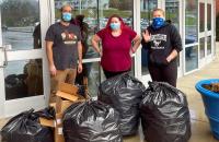 Glenville State University Environmental Science Club advisor Dr. Nabil Nasseri (left) and club members Jessica Green (center) and Veronica Rowse (right) with several bags of recyclable items collected from the Waco Center.