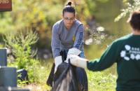 Glenville State College Natural Resource Management students Katlyne Rollyson (center, with tire) and Lexi Pletcher clear trash from around Stonewall Jackson Lake during a recent volunteer clean-up event. (GSC Photo/Kristen Cosner)
