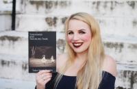Glenville State graduate Tara Wine-Queen with a copy of her book, "Tenderness and Troubling Times"