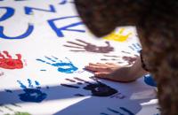 A student applies their handprint to the “These Hands Don’t Hurt” banner. The activity was part of Glenville State University’s Domestic Violence Awareness Month activities. (GSU Photo/Kristen Cosner)
