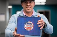 Glenville State University’s Veteran Certifying Official, Charles Yakubow, holds a badge recognizing Glenville State as a select Yellow Ribbon Program school. (GSU Photo/Kristen Cosner)